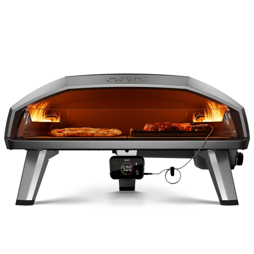 Front view of the Ooni Koda 2 max gas pizza oven with pizza and grizzler pan cooking meat side by side