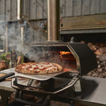 Karu 2 Pro Multi-fuel pizza oven with pizza being removed