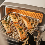 Salmon fillets on a grill inside of the Volt 2 Electric Pizza Oven.