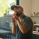 Man eating pizza in a kitchen setting