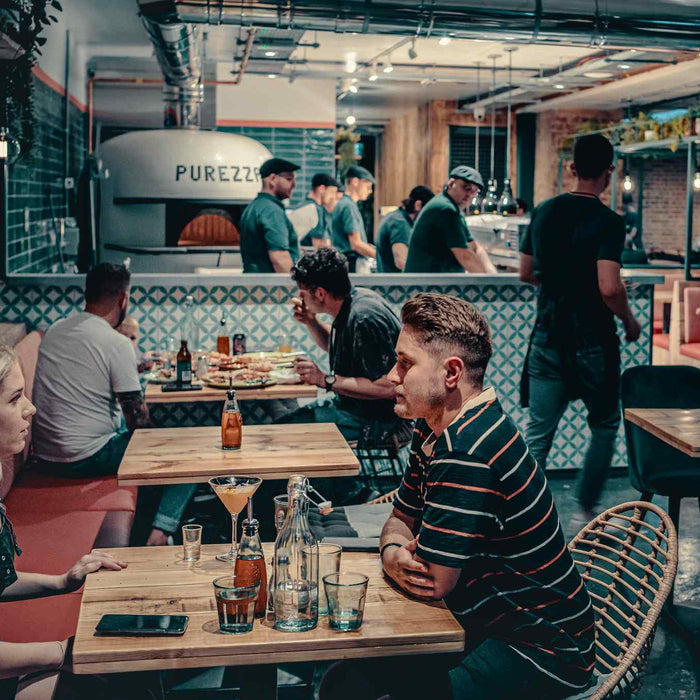 People sitting at tables in a vegan pizza restaurant