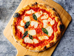 Margherita pizza on a wooden pizza peel