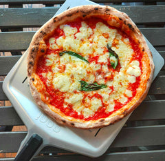 A pizza topped with cheese and tomato made with a pizza beer dough