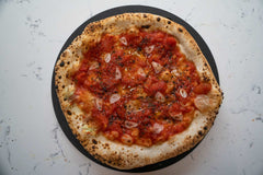 A neapolitan style pizza with tomato sauce topping