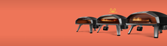 A line-up of the Ooni Koda ovens on an orange background