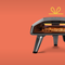 An image of the Koda 2 pizza oven and pizza peels on an orange background