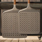 The Signature Pizza Peel range hanging on the side of the Ooni modular table.