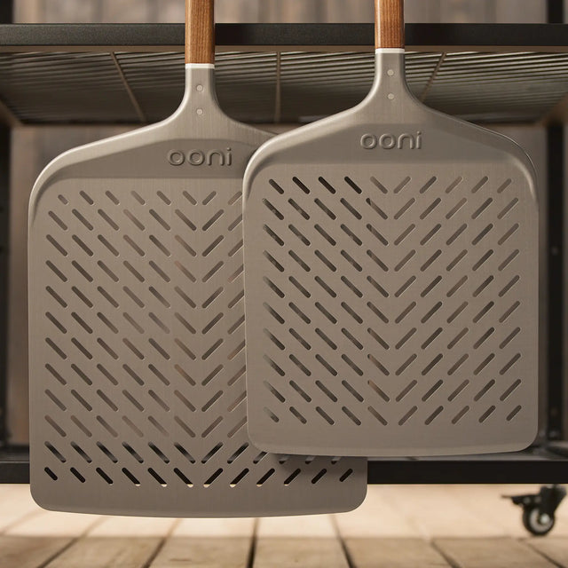 The Signature Pizza Peel range hanging on the side of the Ooni modular table.