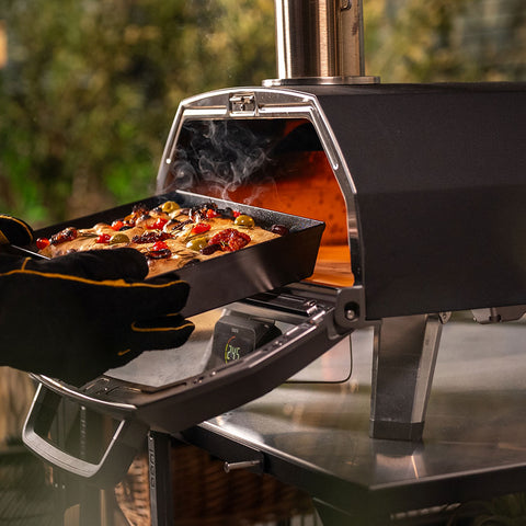 A pair of gloved hands holding a baked Focaccia in the Detroit Pizza Pan 
