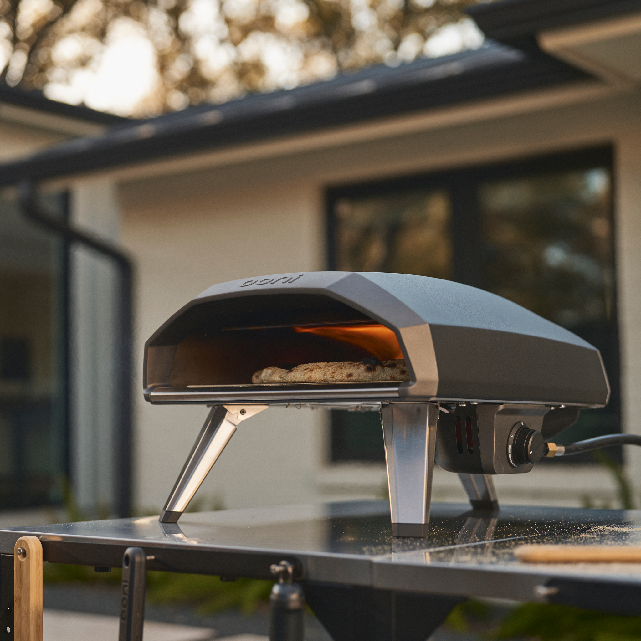 Ooni Koda 2 Gas Powered Pizza Oven on a modular table with a blurred background