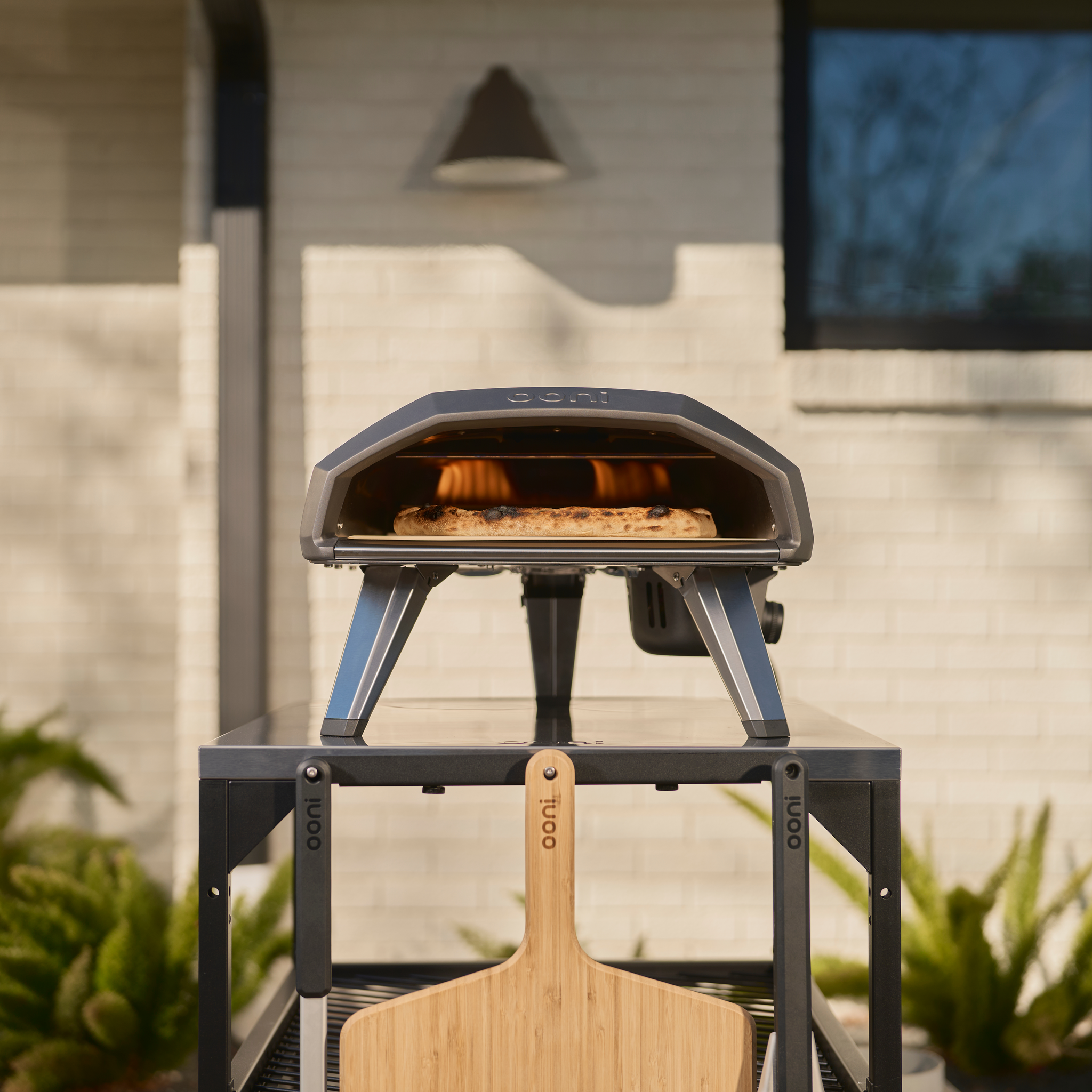 Ooni Koda 2 Gas Powered Pizza Oven in a garden on top of a modular table