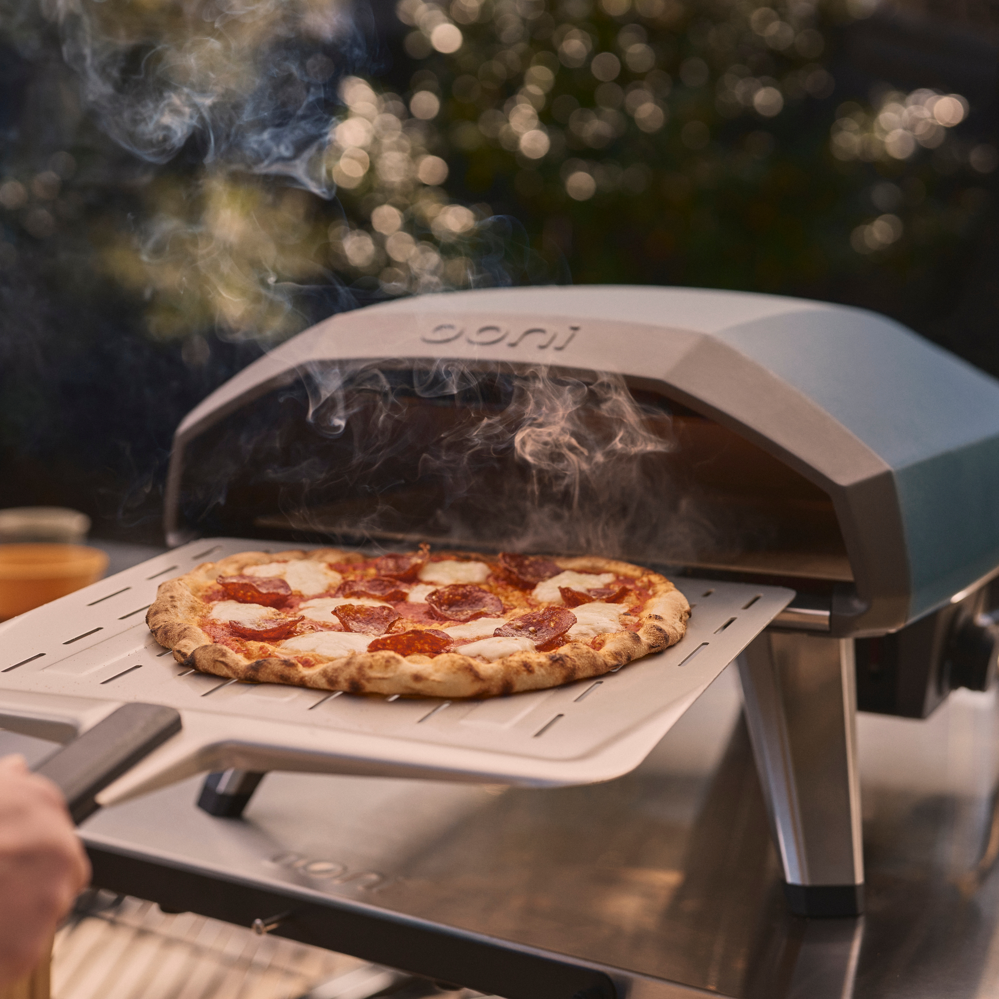 Cooked Pepperoni pizza on top of the Ooni Perforated Peel coming out of the Ooni Koda 2 Gas Powered Pizza Oven