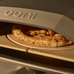 Close-up shot of a pizza being cooked inside of the Ooni Koda 2 on top of the rotating pizza stone