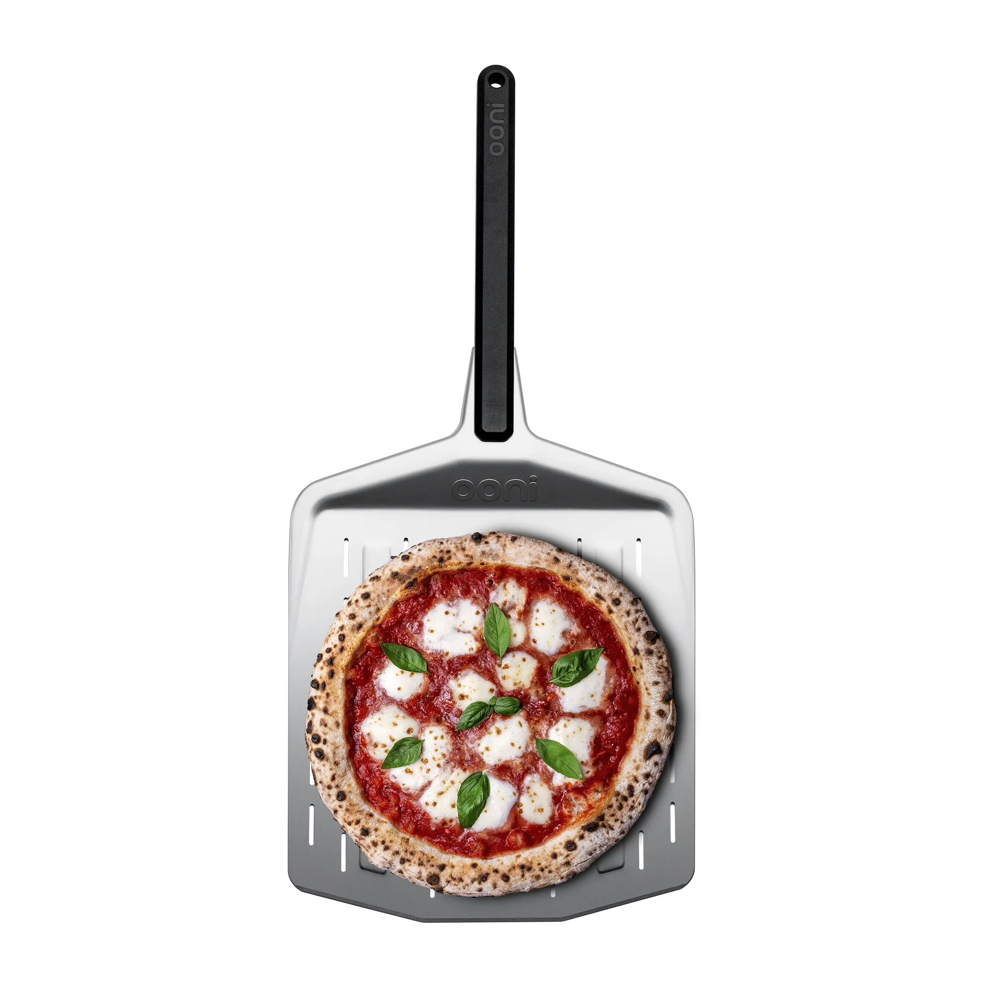 The ooni perforated pizza peel with a cooked pizza on top and a white background.
