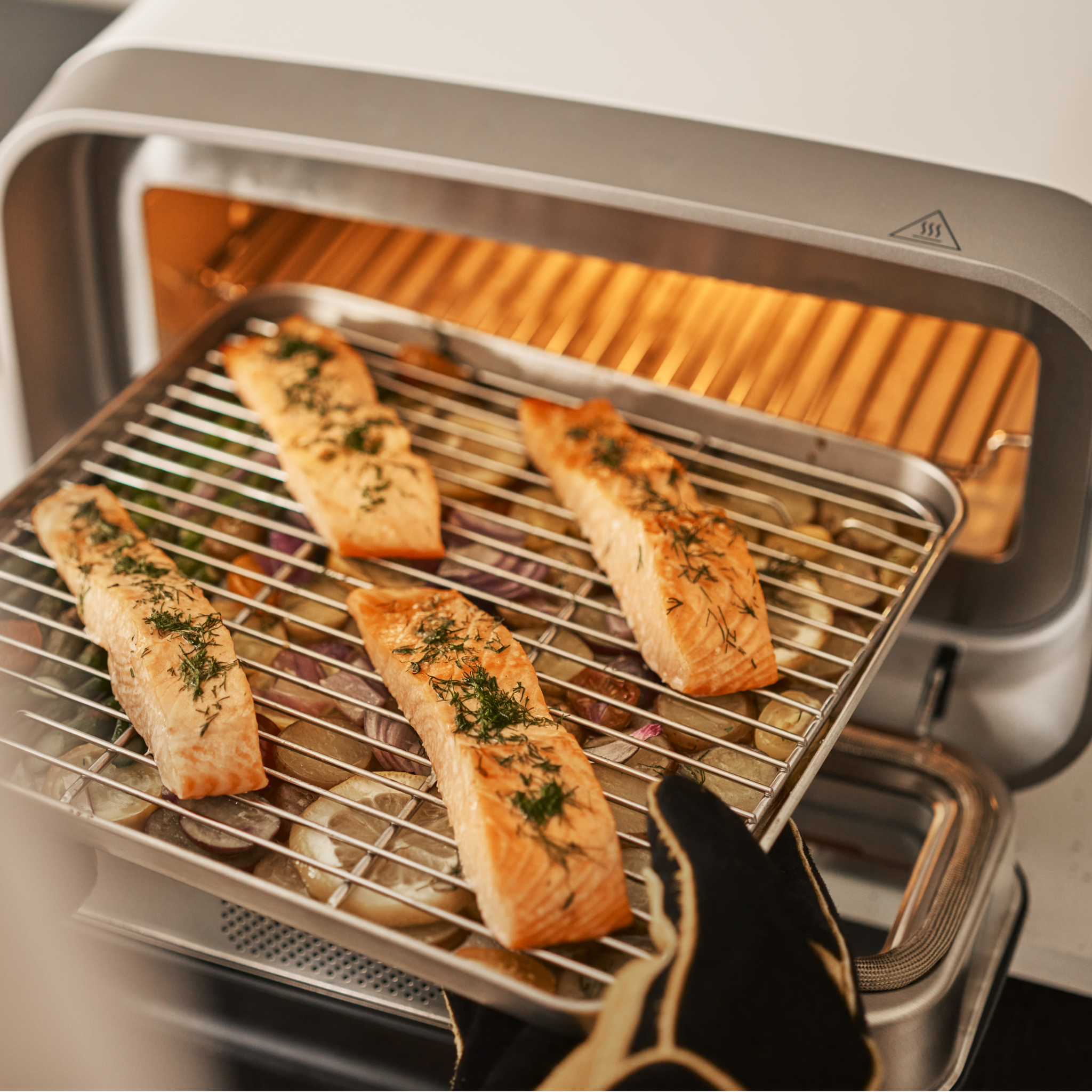 Salmon fillets on a grill inside of the Ooni Volt 2 Pizza Oven.