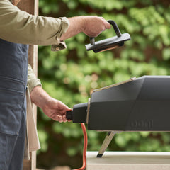 Person using the Karu 2 Pro oven with a blurred green background