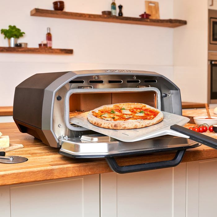 Retrieving pizza on peel from Ooni Volt 12 | Click this image to open up the product gallery modal. The product gallery modal allows the images to be zoomed in on.